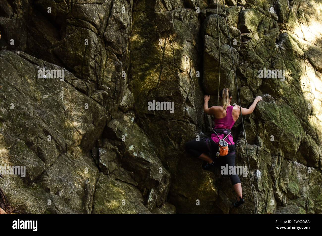 Femme escalade au Sully's Hangout dans Lynn Canyon, North Vancouver, Canada Banque D'Images