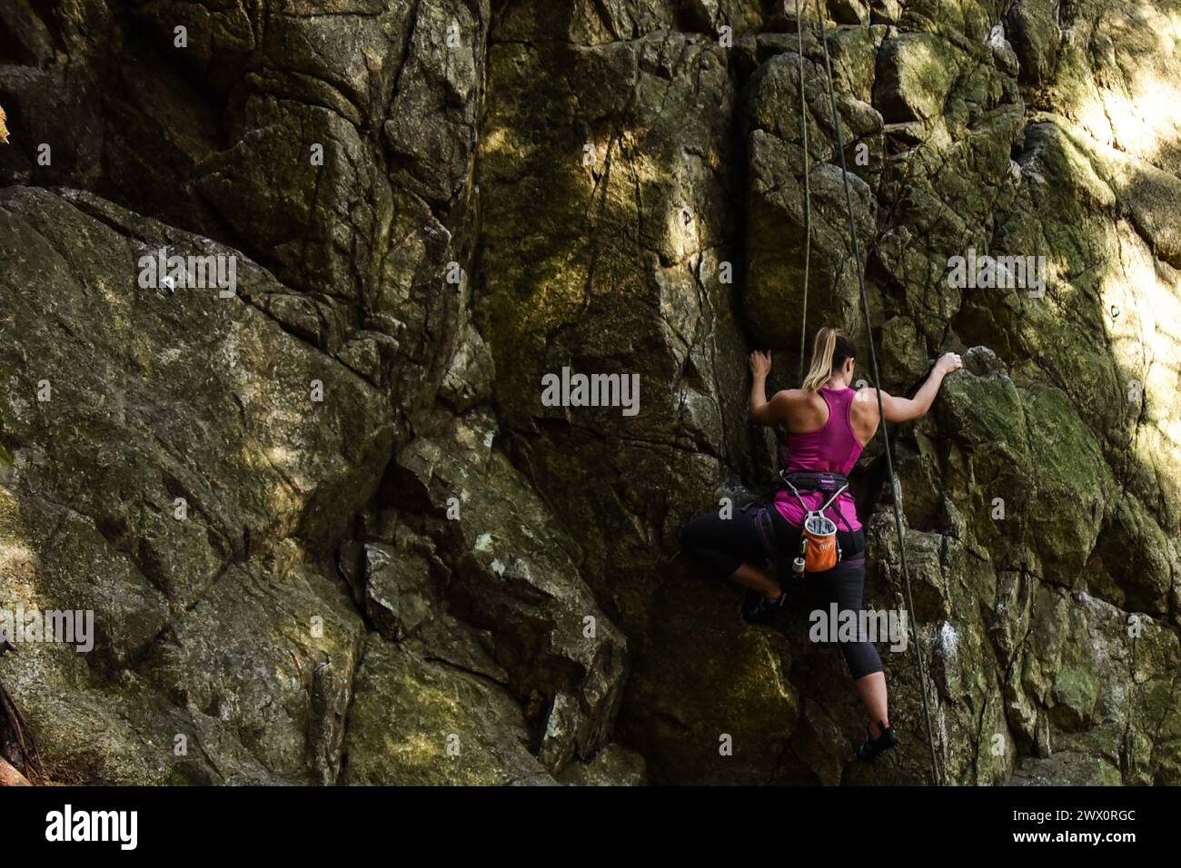 Femme escalade au Sully's Hangout dans Lynn Canyon, North Vancouver, Canada Banque D'Images