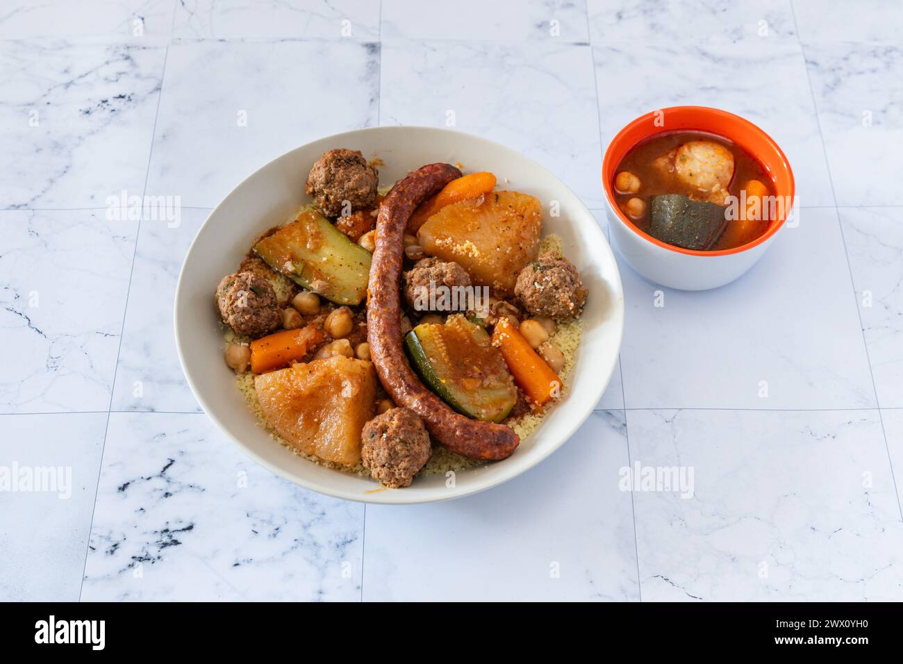 Un fantastique couscous oriental traditionnel et chaud dans une assiette avec sauce harissa Banque D'Images Un fantastique couscous oriental traditionnel et chaud dans une assiette avec sauce harissa Banque D'Images