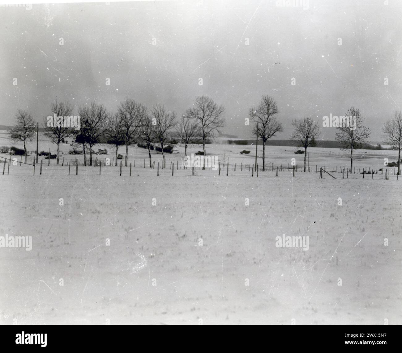 Photos de la seconde Guerre mondiale : légende originale : « les forces blindées du général Patton qui ont relevé 101 hommes aéroportés qui ont tenu Bastogne pendant dix jours, commencent leur route au-delà de Bastogne. Un obus d'artillerie allemand peut être vu exploser au centre de la photo.' env. Décembre 1944 Banque D'Images