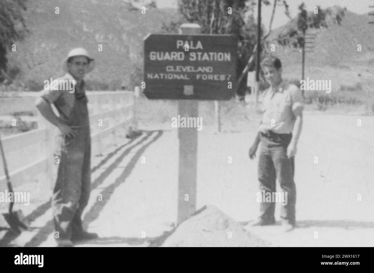 Bande Pala des Indiens de mission : photographie de deux hommes à côté de la station de garde Pala panneau pour la forêt nationale de Cleveland CA. 1936-1942 Banque D'Images