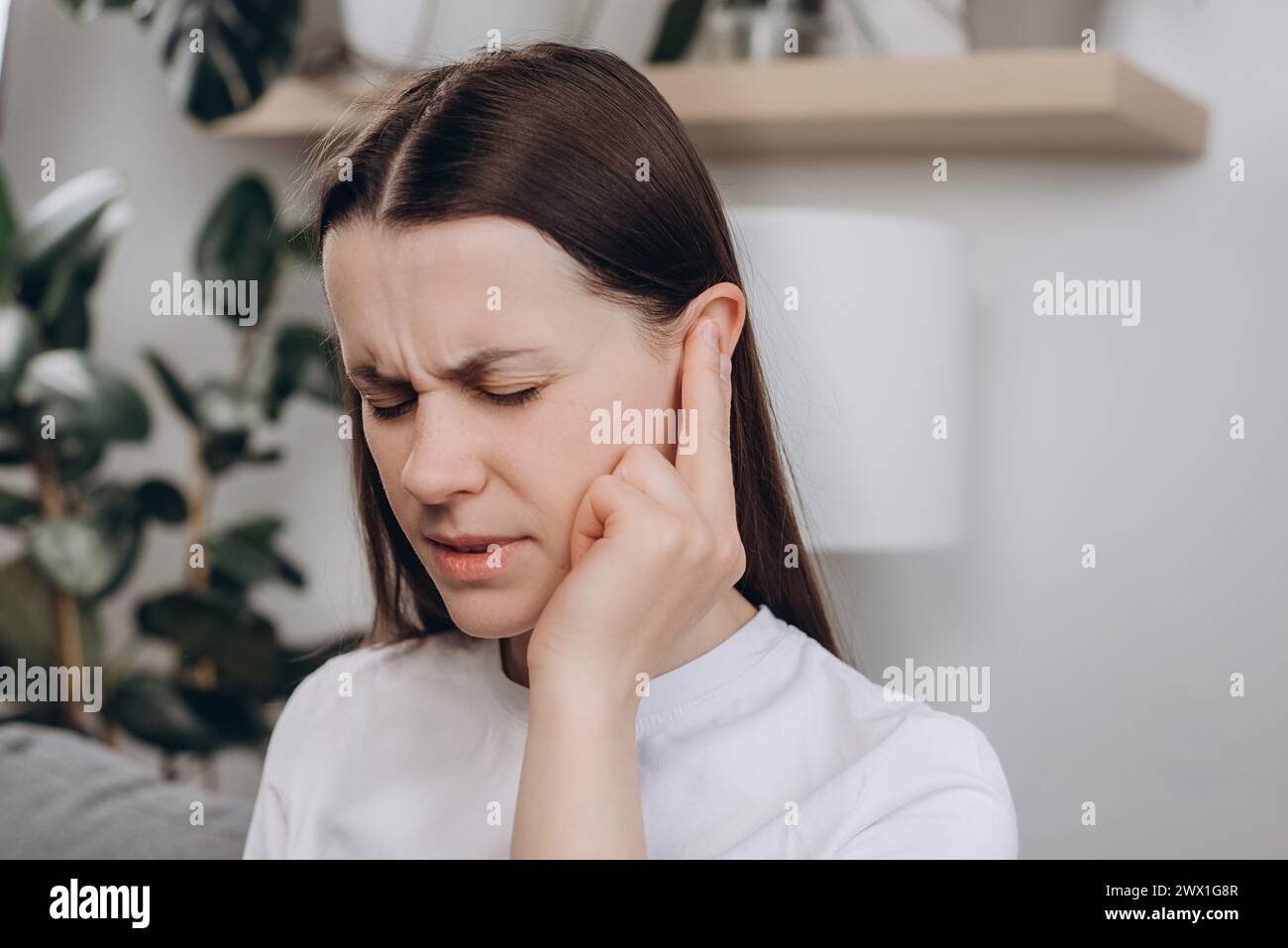 Malheureux bouleversé jeune femme caucasienne 25 ans ont des douleurs à l'oreille ou des maux d'oreille, femme triste souffrant d'otite douloureuse de bruit fort ou bruyant, inflammation. Santé c Banque D'Images