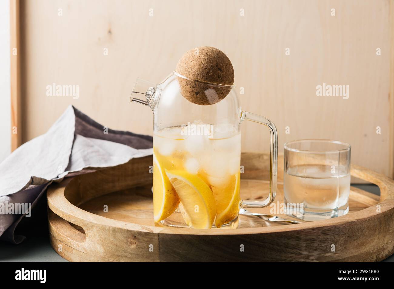 Arrosez avec du citron et de la glace sur un plateau en bois, boisson rafraîchissante. Banque D'Images