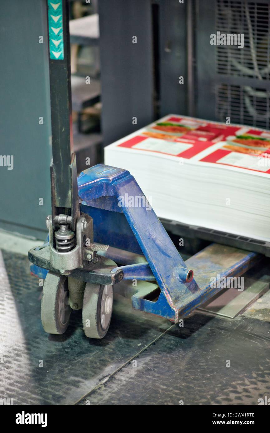 Chariot élévateur, chariot et usine avec papier imprimé dans la distribution, la chaîne d'approvisionnement ou l'entrepôt de fabrication. Gros plan sur l'équipement, la machine ou le transport Banque D'Images