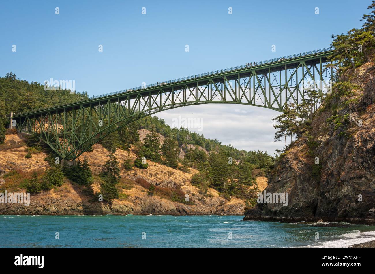 Le pont Deception Pass s'élève haut au-dessus d'une faille entre une falaise rocheuse abrupte et des collines couvertes d'arbres au Deception Pass State Park, Washington. Banque D'Images