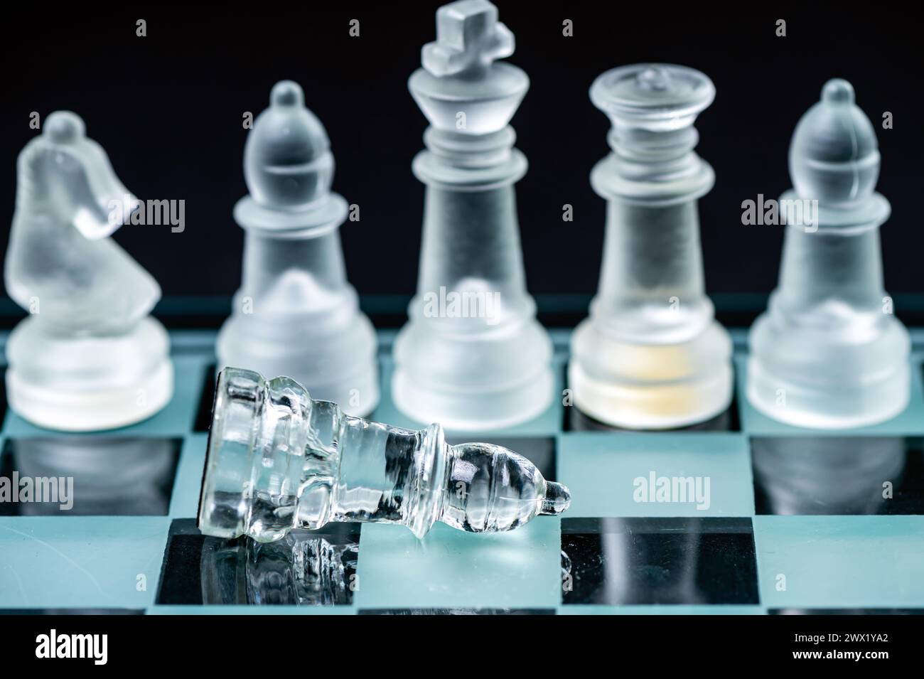 verre transparent, pièces d'échecs transparentes sur un damier, mise au point sélective, gros plan, isolé sur le noir Banque D'Images