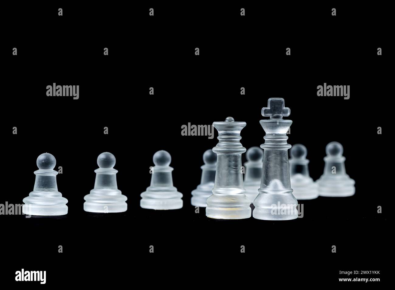 jeu d'échecs en verre transparent sur fond noir, mise au point sélective sur les pièces du roi et de la reine, gros plan Banque D'Images