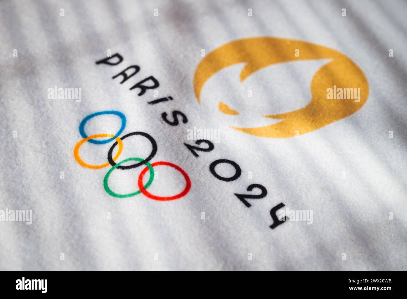PARIS, FRANCE, 26 MARS 2024 : le logo officiel des Jeux olympiques d'été de Paris 2024 en lumière chaude sur serviette blanche Banque D'Images