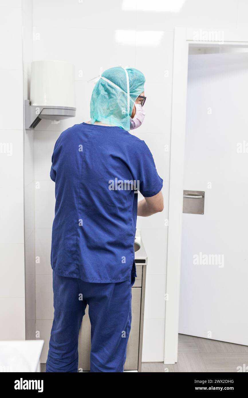 vétérinaire homme chirurgien dans les vêtements épi se préparant à opérer le lavage des mains dans l'évier de la clinique Banque D'Images