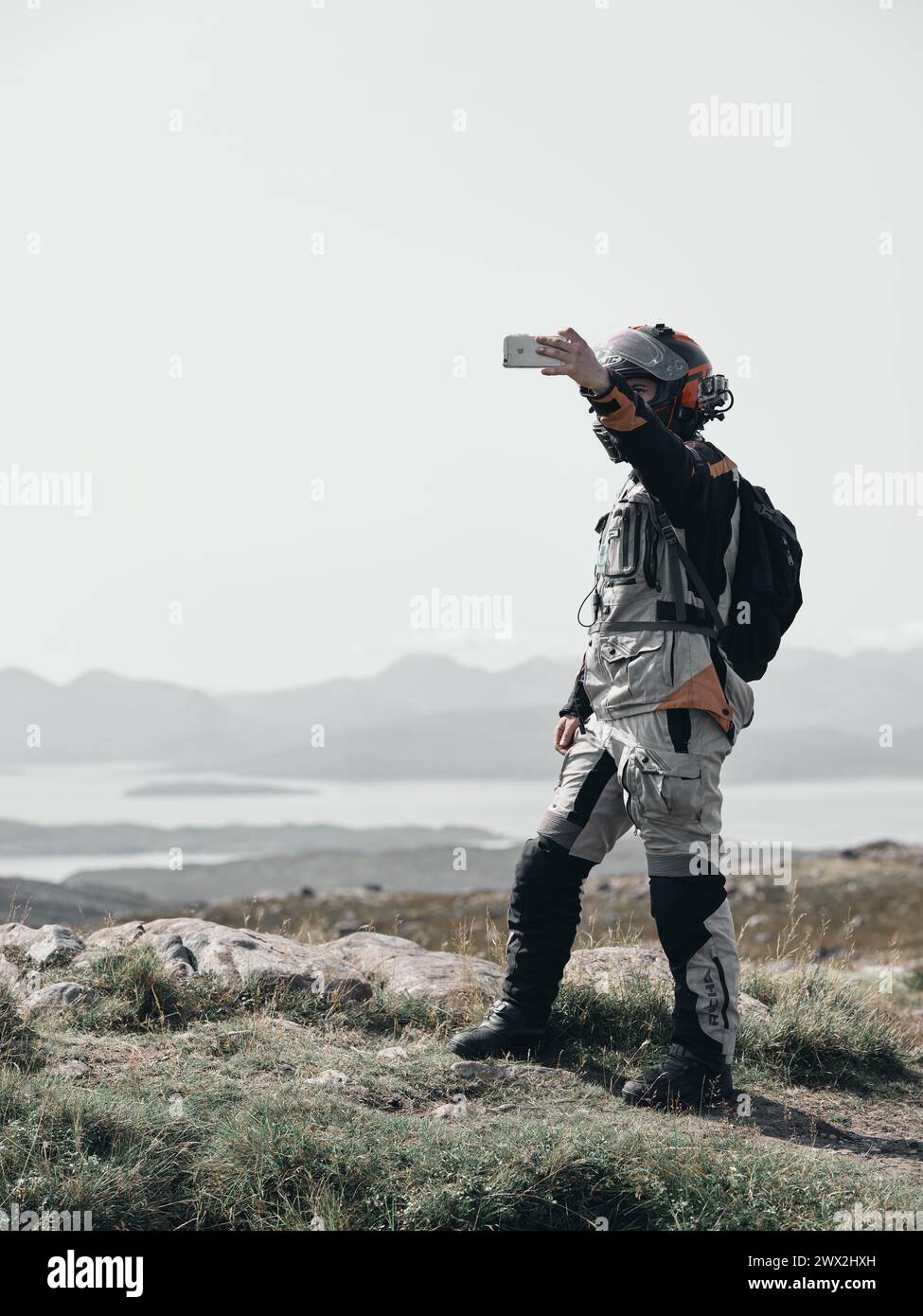 Spaceman ! - Un motard de tourisme ressemblant à un homme de l'espace s'arrête pour prendre un selfie au sommet d'un col de montagne en Écosse Royaume-Uni - étrange visiteur décalé Banque D'Images