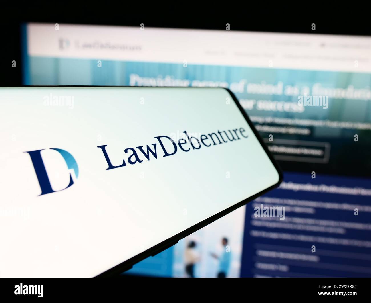 Téléphone portable avec logo de la société d'investissement The Law Debenture Corporation plc devant le site Web. Mettez l'accent sur le centre-gauche de l'écran du téléphone. Banque D'Images