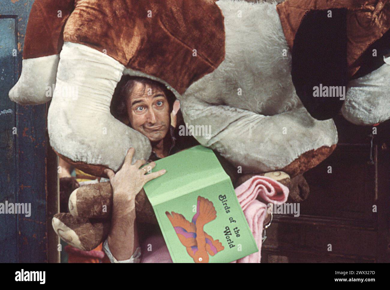 Une photo de 1977 du tournage de Sesame Street avec l'acteur Bob McGrath qui a joué Ben Johnson faisant un visage avec un grand chien en peluche sur sa tête. Dans un studio sur Broadway dans l'Upper West Side de Manhattan. Banque D'Images