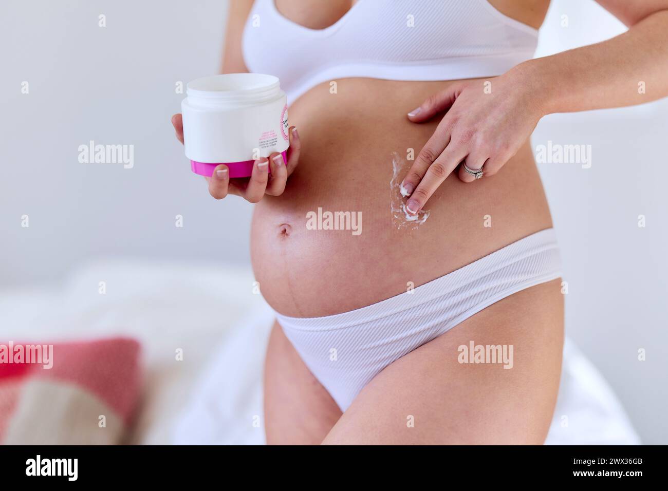 Femme enceinte s'hydratant elle-même Banque D'Images