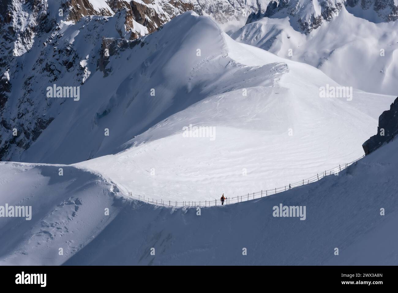 Un skieur seul en silhouette debout sur la crête menant de l'aiguille du midi à la Vallée Blanche dans le massif du Mont Blanc à Chamonix en Fra Banque D'Images