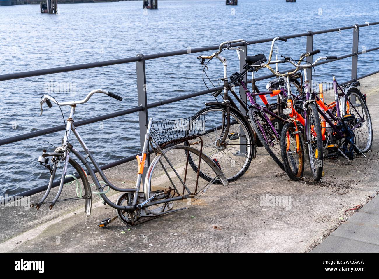 Des bicyclettes à la ferraille, vieilles bicyclettes partiellement pillées et démantelées, dans la HafenCity à Hambourg, sur les rives d'un bassin portuaire, Banque D'Images