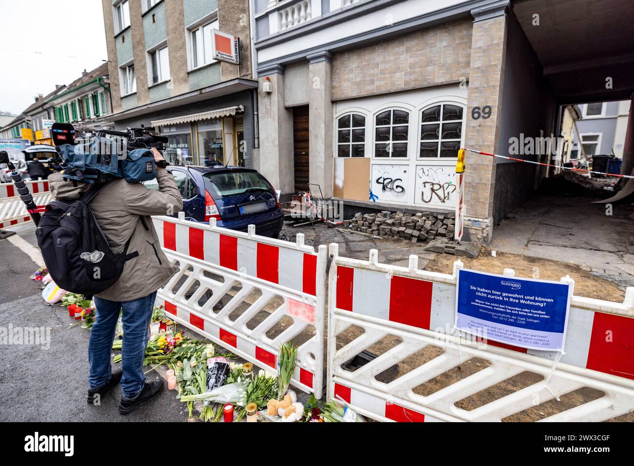 Wuppertal, Allemagne. 27 mars 2024. Un caméraman filme sur les lieux de l'incendie à Solingen après le communiqué de presse du parquet de Wuppertal sur l'incendie mortel à Solingen. Quatre personnes sont mortes dans l'incendie lundi matin et plusieurs ont été blessées. Credit : Christoph Reichwein/dpa - ATTENTION : les plaques d'immatriculation ont été pixelisées pour des raisons légales/dpa/Alamy Live News Banque D'Images