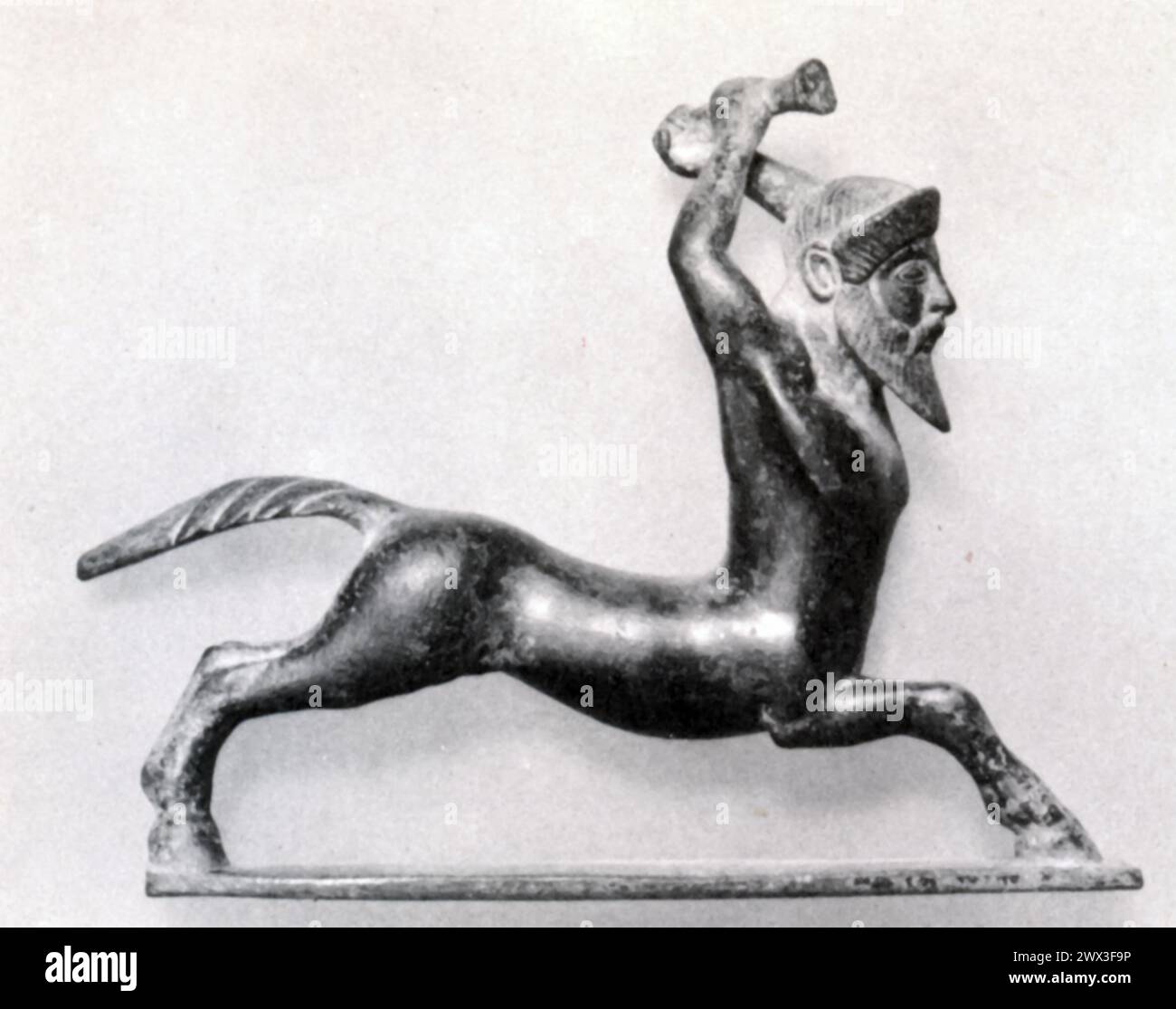 Une statuette en bronze représentant un centaure en bataille, originaire de Grèce au vie siècle av. J.-C. les Centaures, créatures mythologiques avec le haut du corps d'un humain et le bas du corps d'un cheval, étaient des sujets populaires dans l'art et la mythologie grecs antiques, symbolisant souvent la double nature de l'homme combiner le rationnel et le sauvage. Banque D'Images