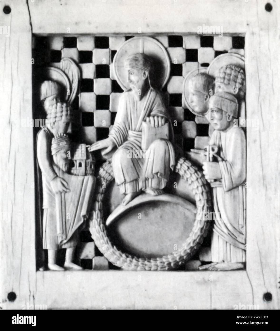 Une plaque en ivoire du Xe siècle, représentant l'empereur Otton Ier présentant une église au Christ. Cet artefact pourrait être d'origine allemande ou italienne, reflétant les échanges culturels et artistiques au sein du Saint-Empire romain germanique pendant la Renaissance ottonienne, une période marquée par un renouveau de l'art, de l'architecture et de l'érudition inspirés par des thèmes chrétiens et classiques. Banque D'Images