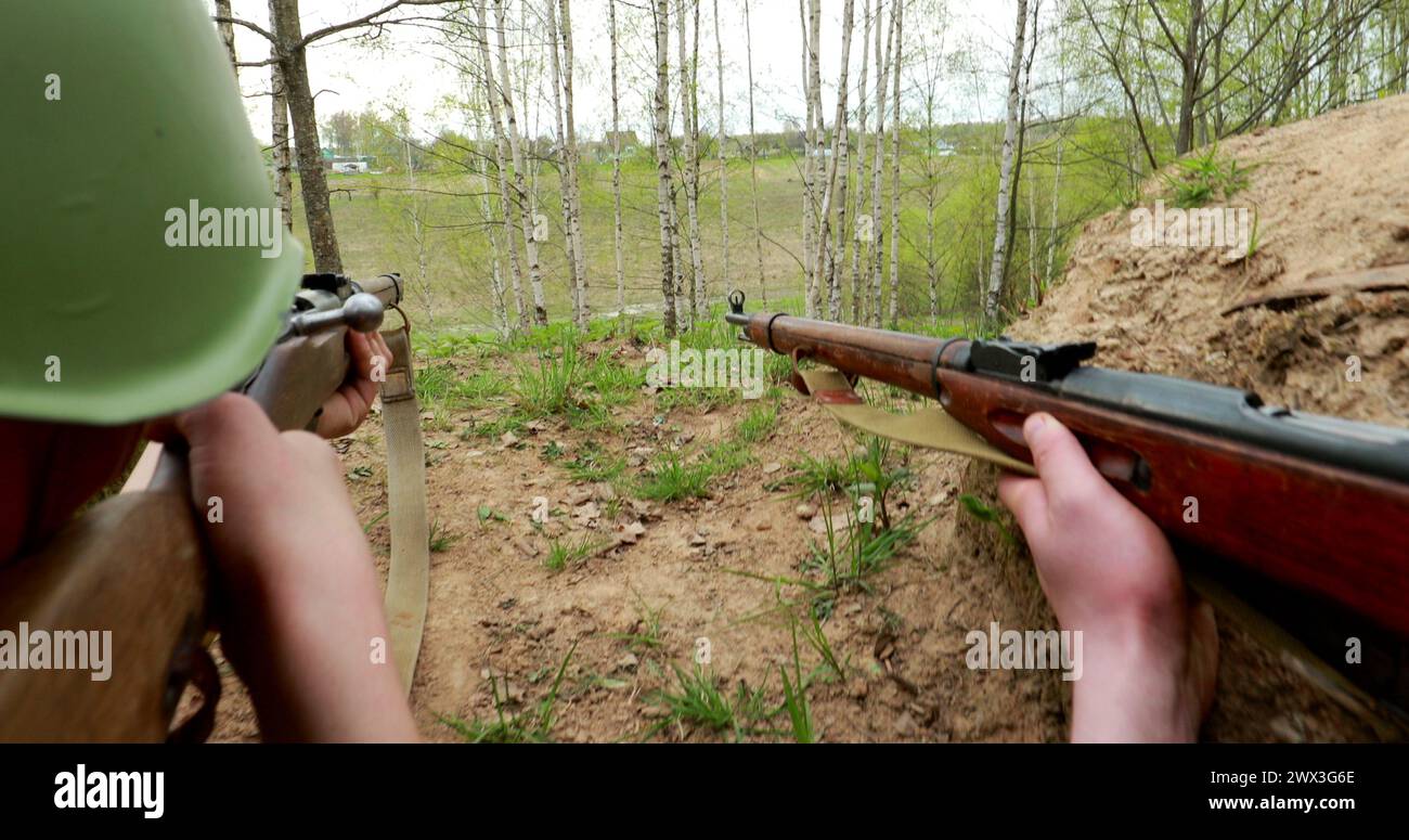 Reconstituteurs habillés en soldat russe soviétique visant avec des fusils. Les soldats tirent avec un fusil. Uniforme de soldat russe soviétique Banque D'Images