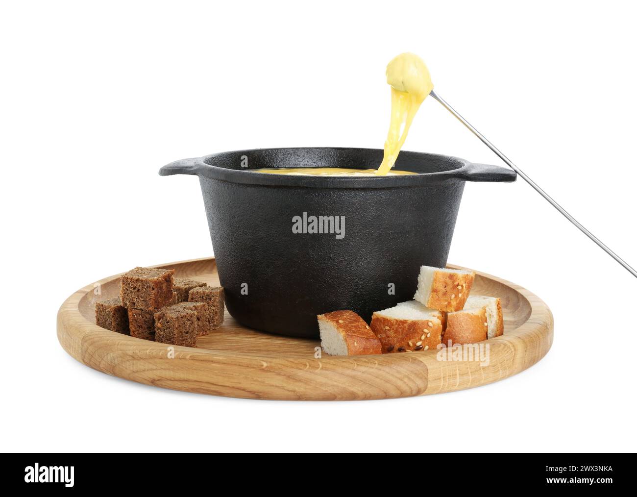 Tremper un morceau de pain dans une casserole à fondue avec du fromage fondu savoureux isolé sur blanc Banque D'Images
