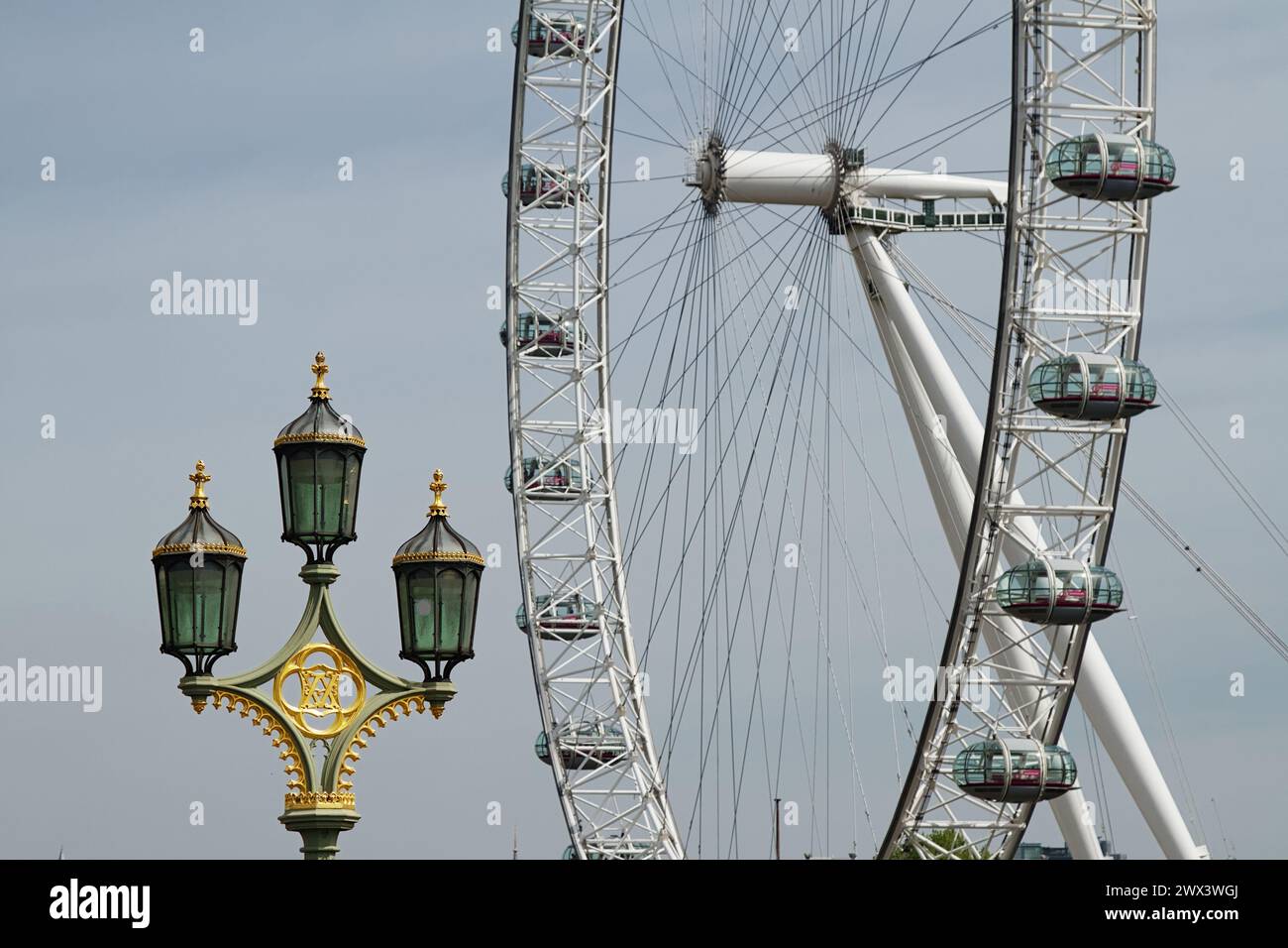 Lampe triple standard octogonale de style gothique Revival avec lampes à gaz avec London Eye en arrière-plan, Westminster Bridge, Londres, royaume-uni Banque D'Images