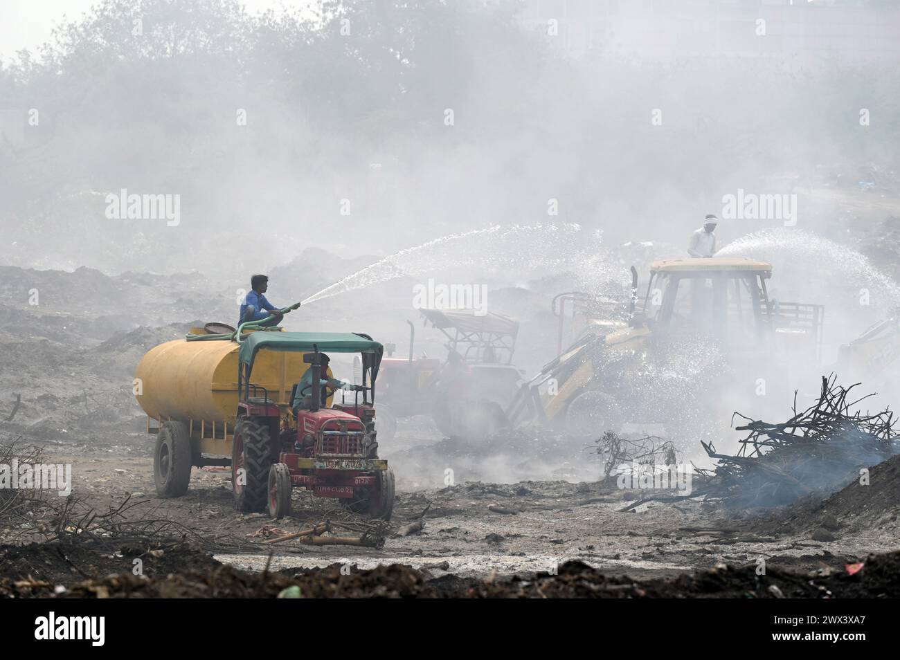 Noida, Inde. 27 mars 2024. NOIDA, INDE - MARS 27 : les pompiers tentent d'éteindre un incendie dans un dépôt de déchets horticoles dans le secteur 32 le 27 mars 2024 à Noida, en Inde. Le feu a commencé vers 18 heures lundi et a englouti une zone d'environ 1,5 km de large et 2 km de long dans le secteur 32, a déclaré le chef des pompiers de GB Nagar. Tous les déchets horticoles de partout à Noida sont déversés sur cette parcelle pour être convertis en compost. (Photo de Sunil Ghosh/Hindustan Times/Sipa USA) crédit : Sipa USA/Alamy Live News Banque D'Images