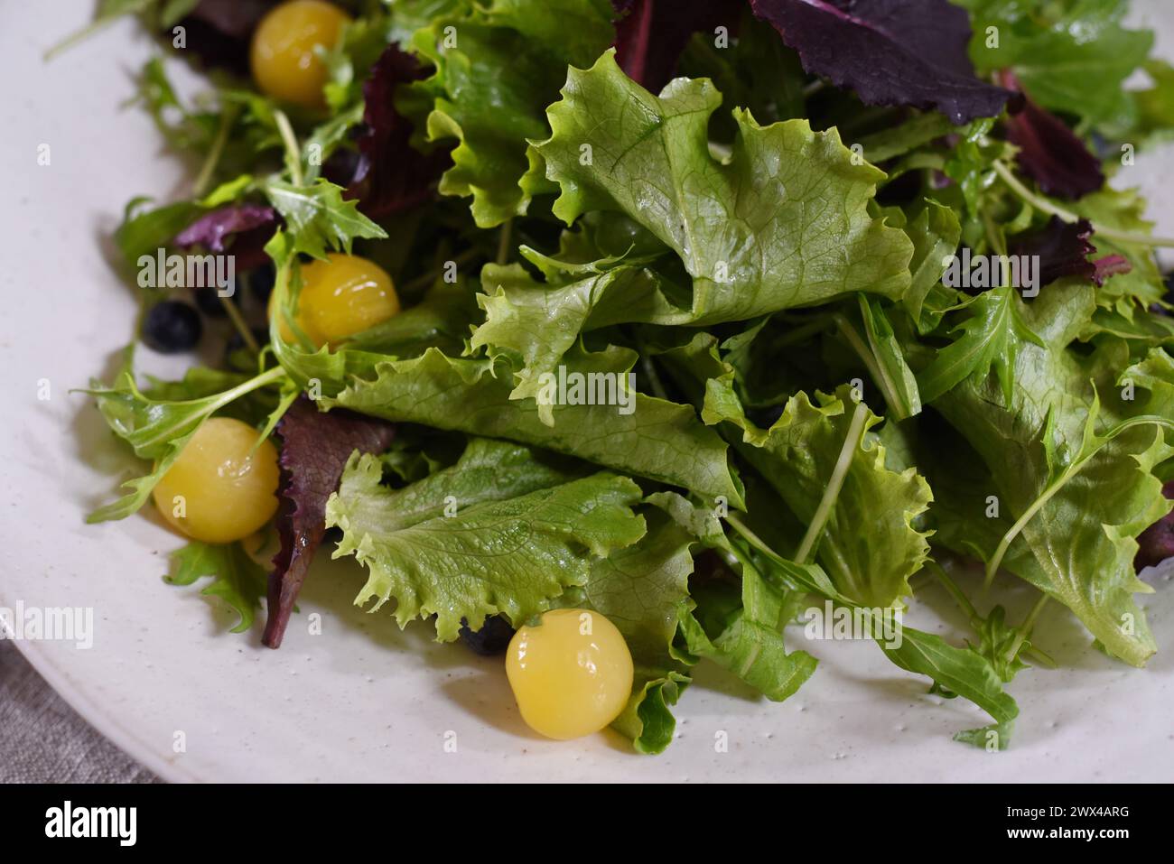 Une salade verte de jardin avec des tomates cerises jaunes Banque D'Images