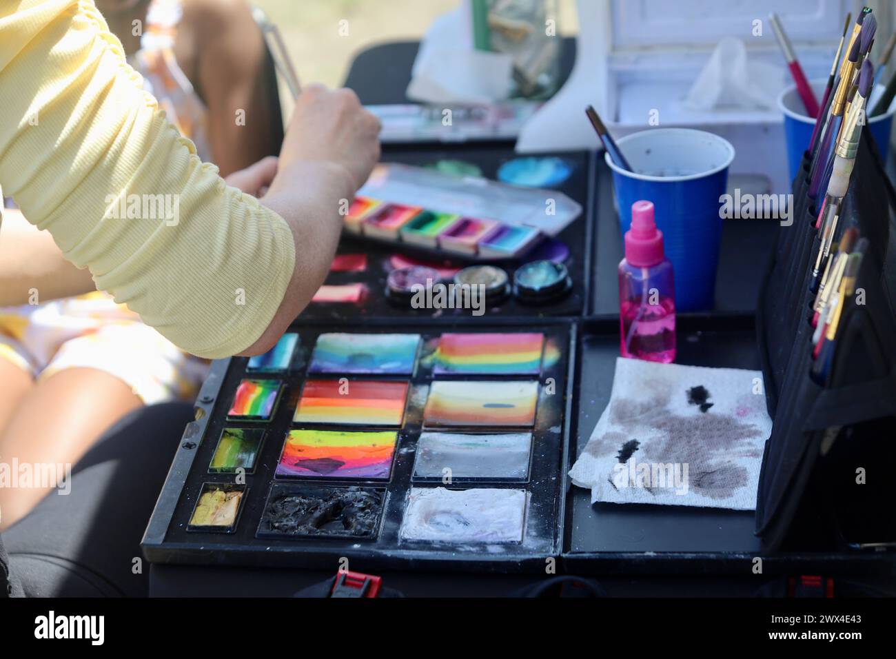 Une personne est assise à une table aux couleurs vives avec des teintes vibrantes Banque D'Images