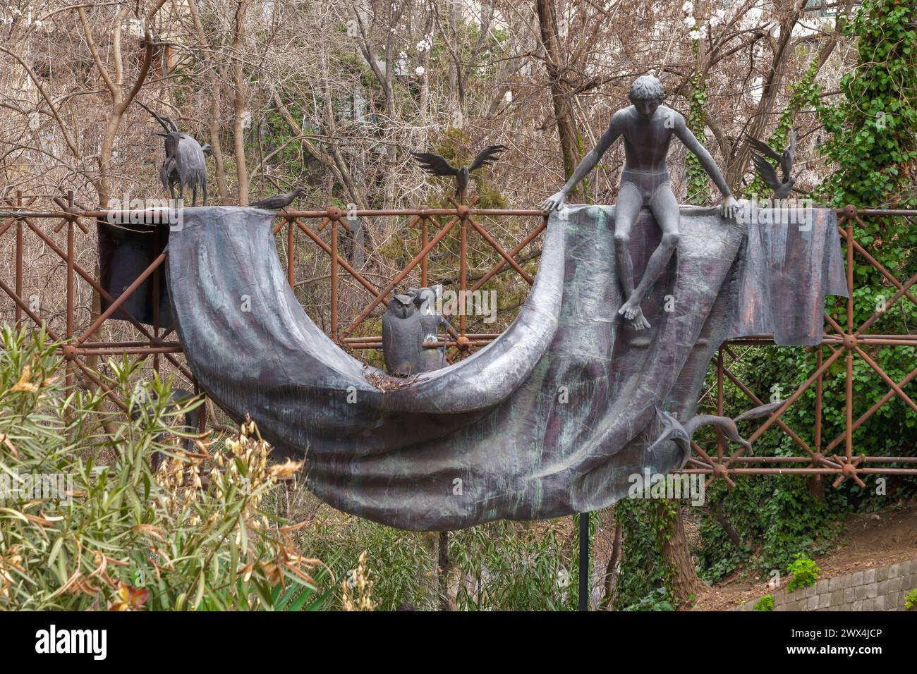 Un garçon et des animaux fabriqués en métal sont assis sur une sculpture en tissu, mêlant art et environnement naturel à l'entrée du parc Mziuri. Tbilissi, Géorgie - 27 février 2024. Banque D'Images