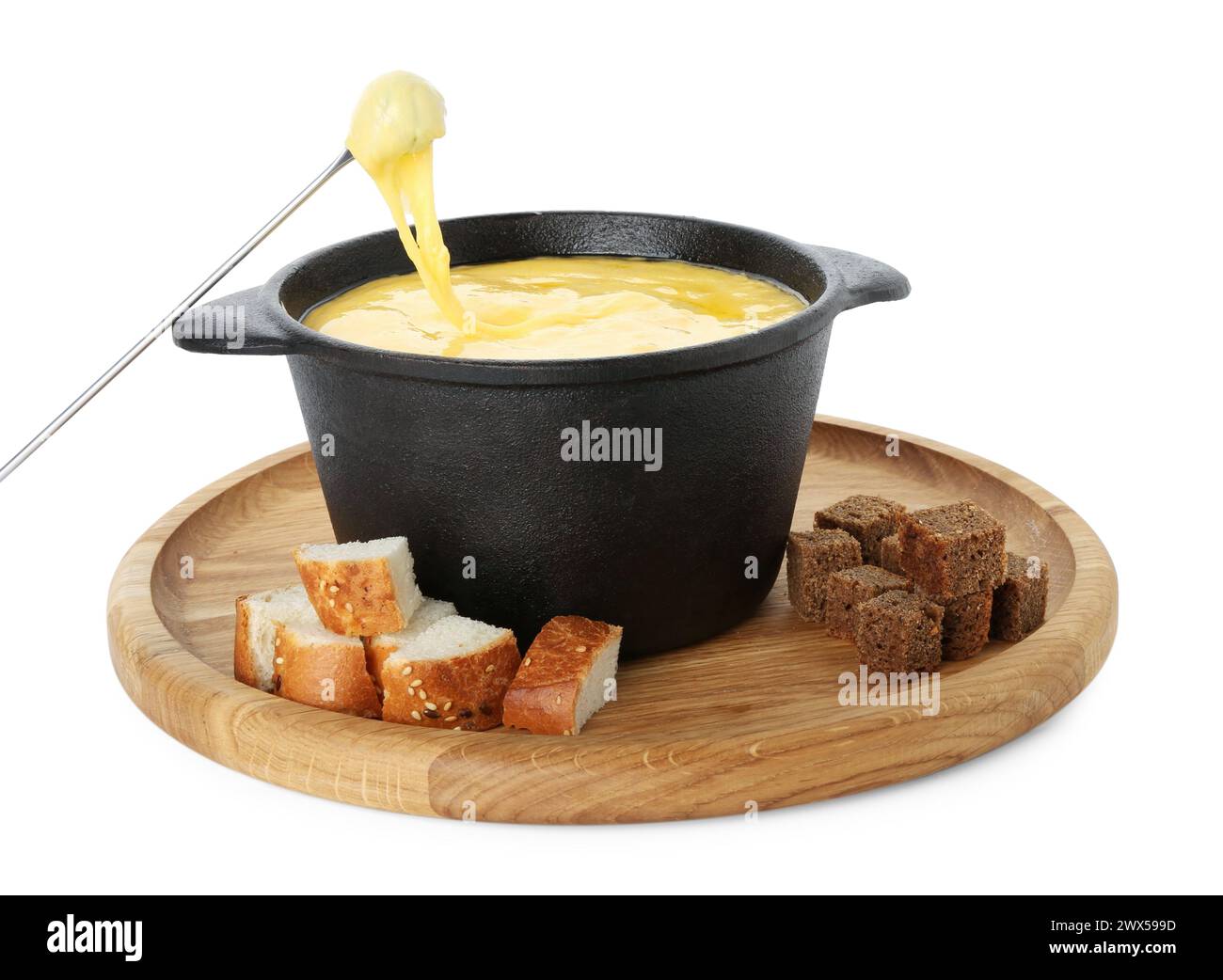 Tremper un morceau de pain dans une casserole à fondue avec du fromage fondu savoureux isolé sur blanc Banque D'Images