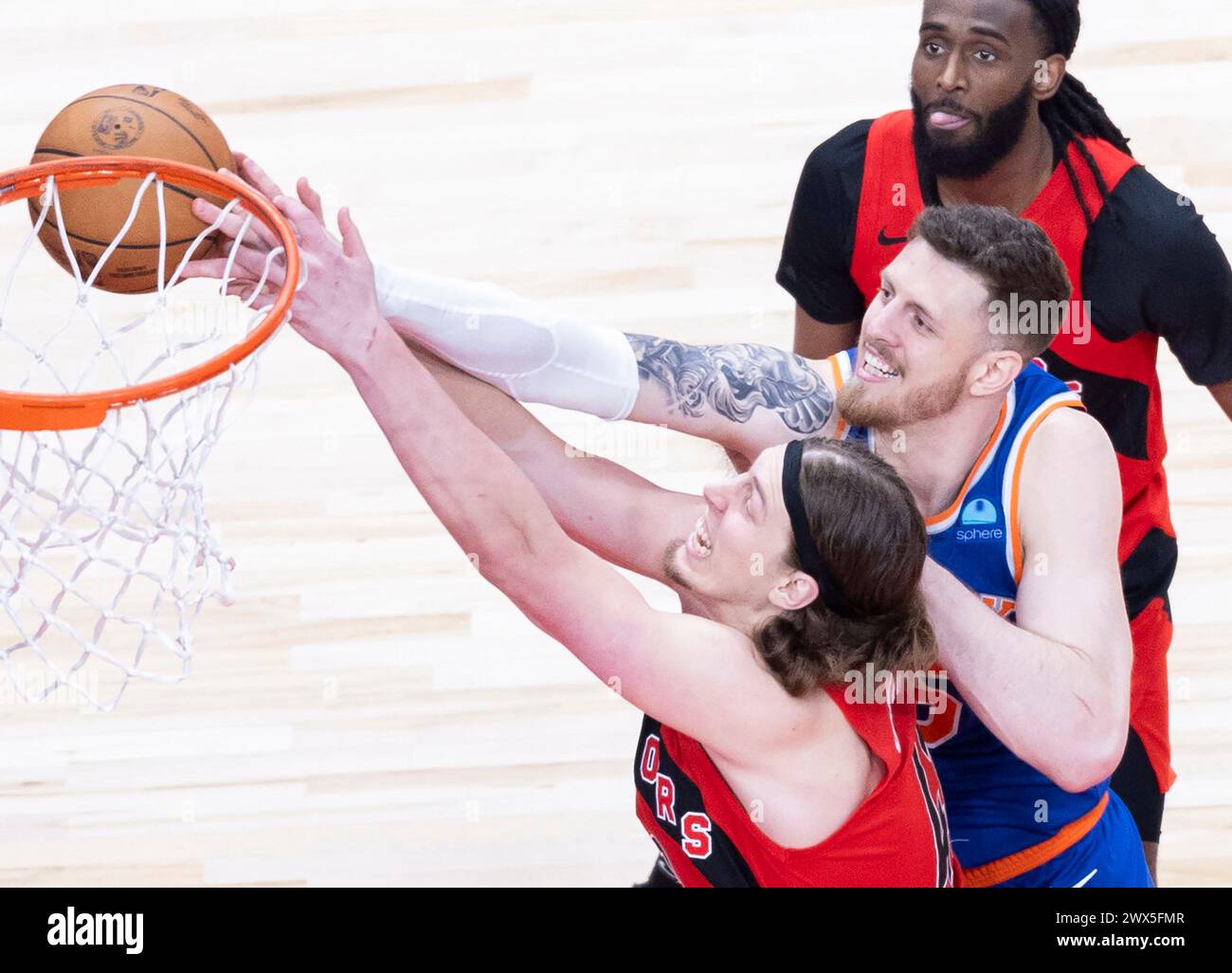 Toronto, Canada. 27 mars 2024. Kelly Olynyk (avant) des Raptors de Toronto se bat pour un rebond avec Isaiah Hartenstein des Knicks de New York lors du match de la saison régulière de la NBA 2023-2024 à Toronto, Canada, le 27 mars 2024. Crédit : Zou Zheng/Xinhua/Alamy Live News Banque D'Images