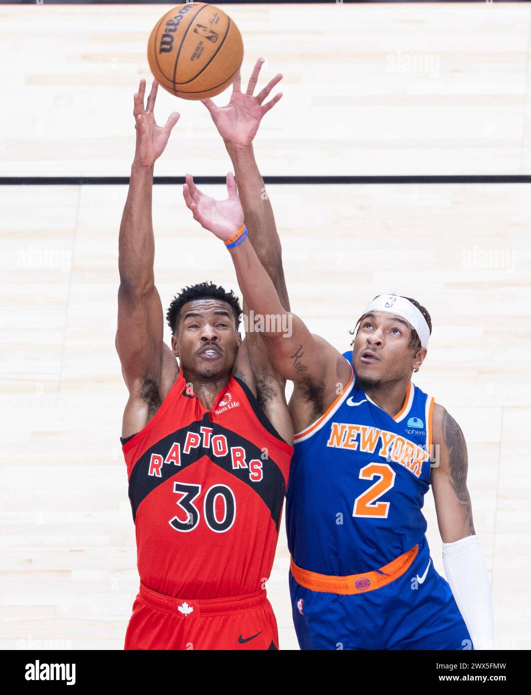 Toronto, Canada. 27 mars 2024. Ochai Agbaji (G) des Raptors de Toronto se bat pour un rebond avec Miles McBride des Knicks de New York lors du match de la saison régulière de la NBA 2023-2024 à Toronto, Canada, le 27 mars 2024. Crédit : Zou Zheng/Xinhua/Alamy Live News Banque D'Images