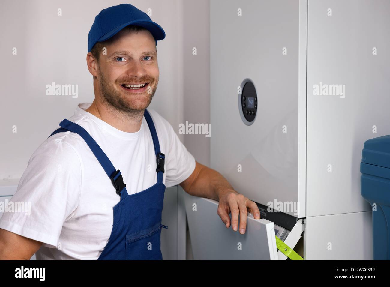 Service d'entretien et de réparation souriant ingénieur travaillant avec maison chauffage au gaz Banque D'Images