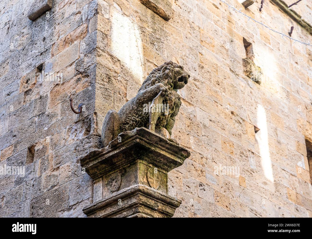 Sculpture d'un lion dans la façade du Palazzo dei priori médiéval, construit au 13ème siècle, Volterra, région Toscane, Italie Banque D'Images