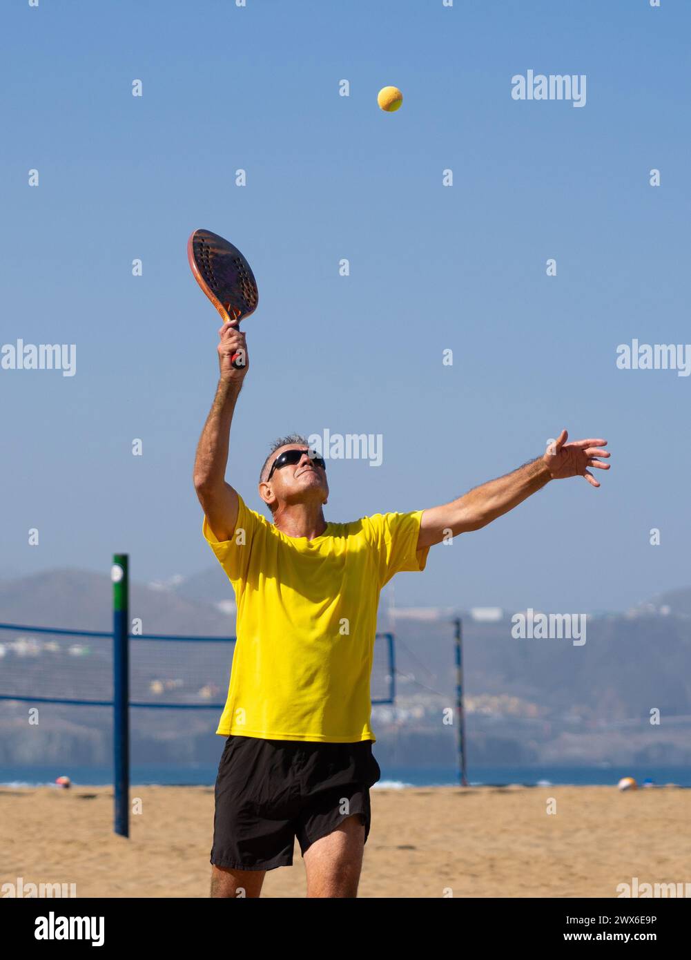 Homme de plus de 60 ans jouant au tennis de plage. Homme âgé avec un mode de vie sain Banque D'Images