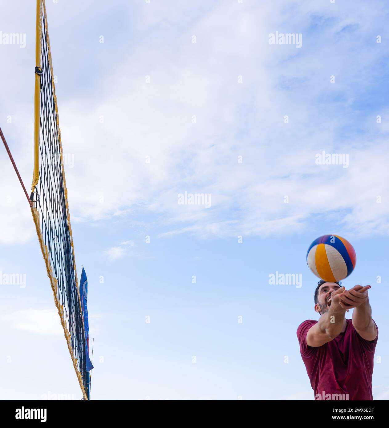 Joueur de Beach volley frappant la balle Banque D'Images