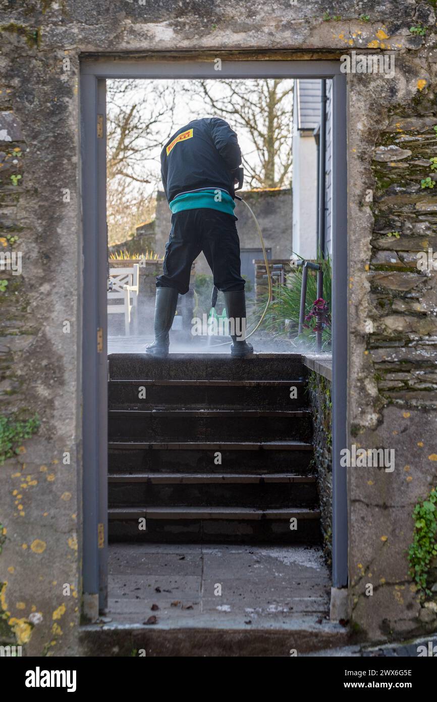 Homme lavage à pression d'un jardin domestique en Irlande. Banque D'Images