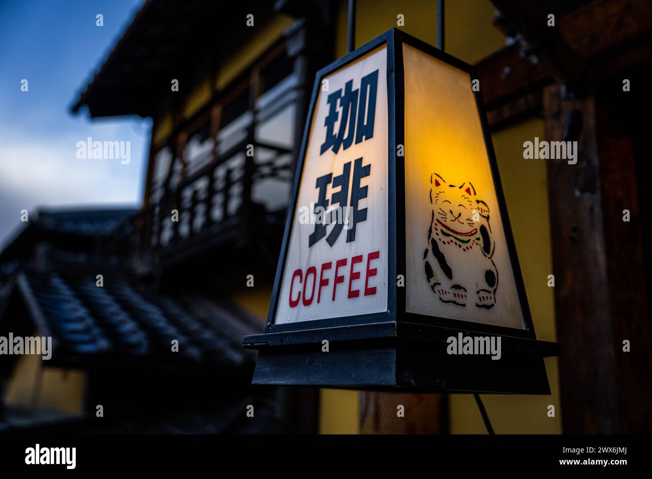 Un signe traditionnel de café de lanterne japonaise avec des bâtiments japonais traditionnels en arrière-plan. Banque D'Images