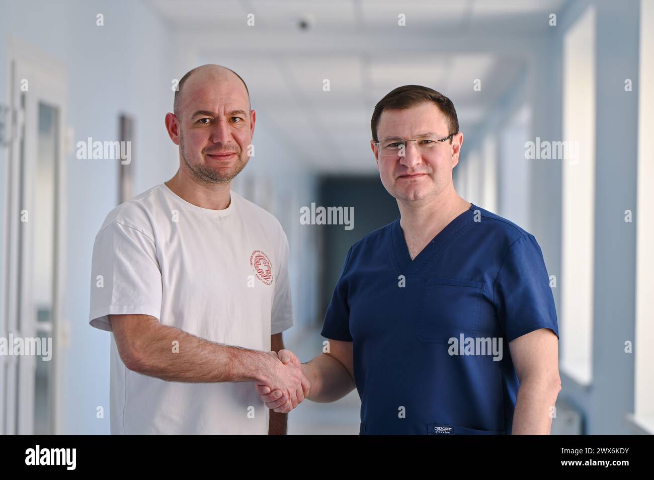 LVIV, UKRAINE - MARS 27, 2024 - Chef du Centre cardiaque et vasculaire de la première Association médicale territoriale de Lviv Roman Domashych (l) et chirurgien cardiaque de premier plan et directeur adjoint de l'Institut national Amosov de chirurgie cardiovasculaire Kostiantyn Rudenko se serrent la main alors qu'ils posent pour une photo après avoir effectué une chirurgie à cœur ouvert en collaboration avec des spécialistes de l'Institut National Amosov de chirurgie cardiovasculaire utilisant la méthode Ferrazzi à l'occasion Hôpital clinique de Panteleimon, Lviv, Ukraine occidentale. Banque D'Images