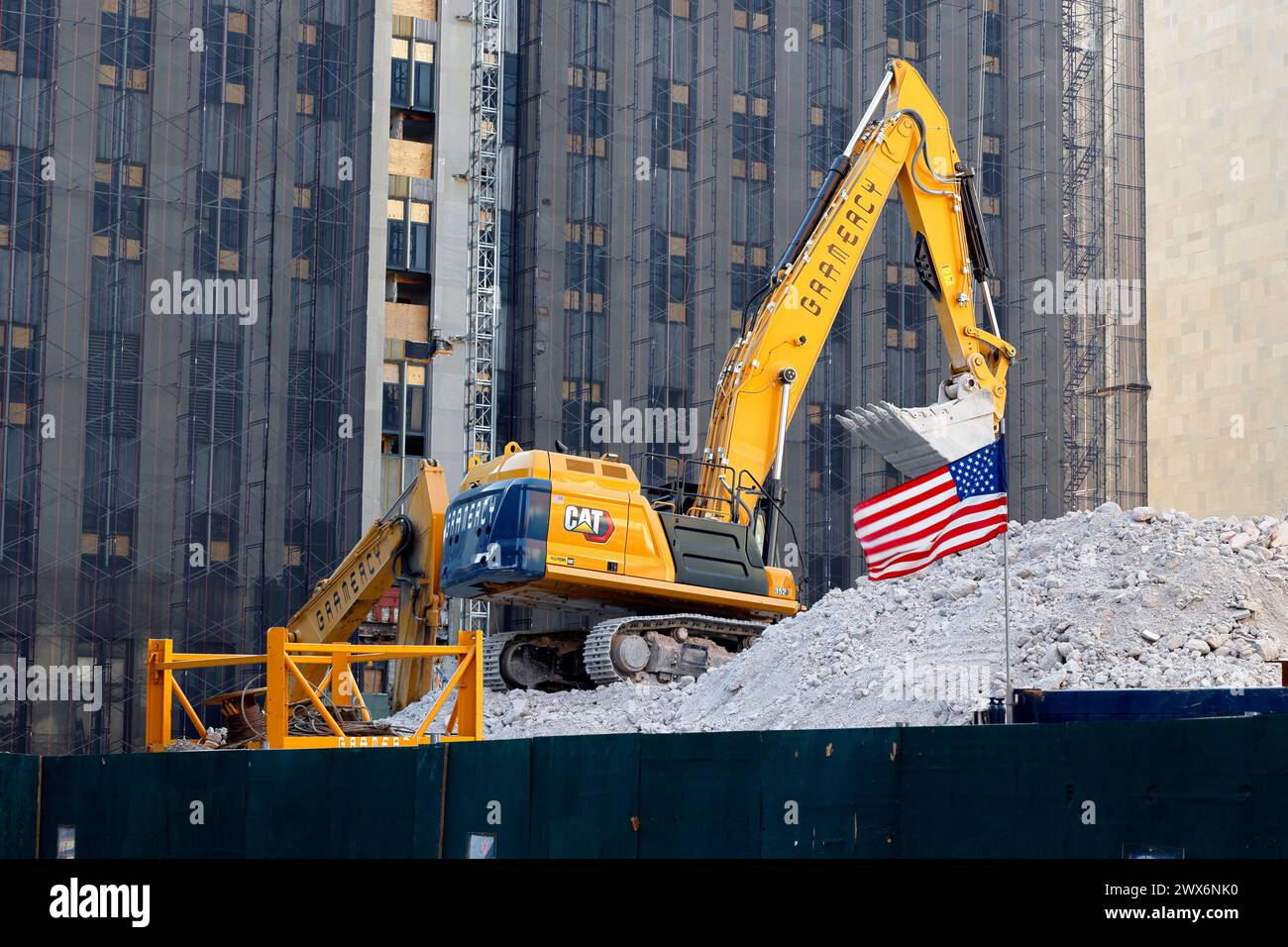 Une excavatrice et un drapeau américain sur les débris de construction sur le site de démolition de la nouvelle prison de Downtown Manhattan, New York. Banque D'Images