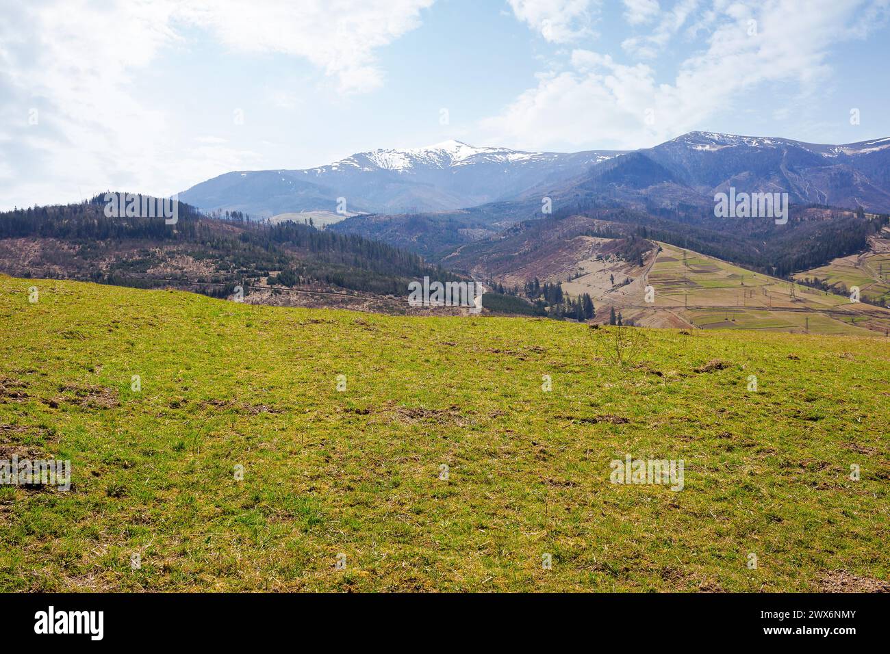 paysage de campagne des carpates au début du printemps. paysage rural montagneux avec des collines couvertes d'herbe altérée. chaude journée ensoleillée Banque D'Images