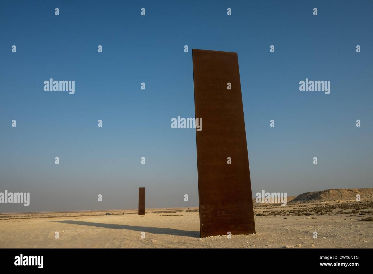 Brouq, Qatar. 28 mars 2024. La photo du dossier datée du 19 novembre 2021 montre la sculpture « East-West/West-East » de l’artiste américain Richard Serra, dans la réserve naturelle de Brouq au Qatar, à une heure de route à l’ouest de la capitale Doha. L’œuvre est composée de quatre plaques d’acier, chacune de plus de quatorze mètres de hauteur, au milieu du désert. Richard Serra vient de décéder, en mars 2024, à l’âge de 85 ans. Photo Balkis Press/ABACAPRESS.COM crédit : Abaca Press/Alamy Live News Banque D'Images