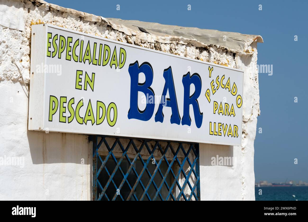 Panneau à l'extérieur d'un bar rustique peint en blanc, qui se spécialise dans les fruits de mer avec service à emporter, sur la plage à Algeciras en Espagne. Banque D'Images