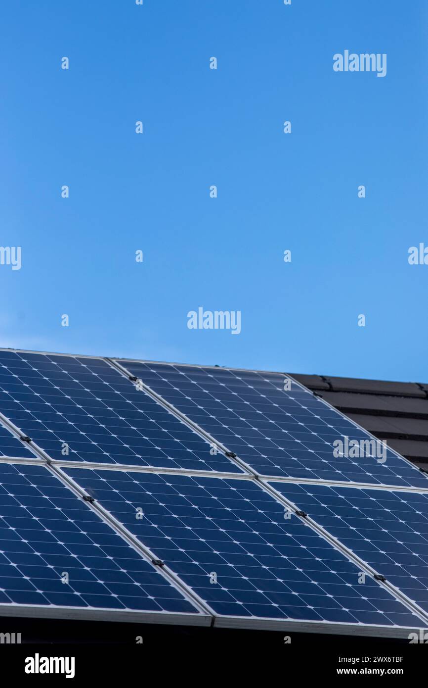 L'énergie solaire joue un rôle limité dans la production d'électricité au Royaume-Uni. Il y avait peu d'installations jusqu'en 2010, lorsque le gouvernement britannique a imposé des subventions sous la forme d'un tarif de rachat (FIT), payé par tous les consommateurs d'électricité. Au cours des années suivantes, le coût des panneaux photovoltaïques (PV) a baissé et les taux D'AJUSTEMENT pour les nouvelles installations ont été réduits progressivement jusqu'à ce que le régime ferme aux nouvelles applications en 2019. En 2023, plus de 14,4 gigawatts (GW) avaient été installés, dont un tiers solaire sur les toits. Maisons et maisons à Queensbury, West Yorkshire, Royaume-Uni avec des panneaux solaires par une journée ensoleillée. Banque D'Images