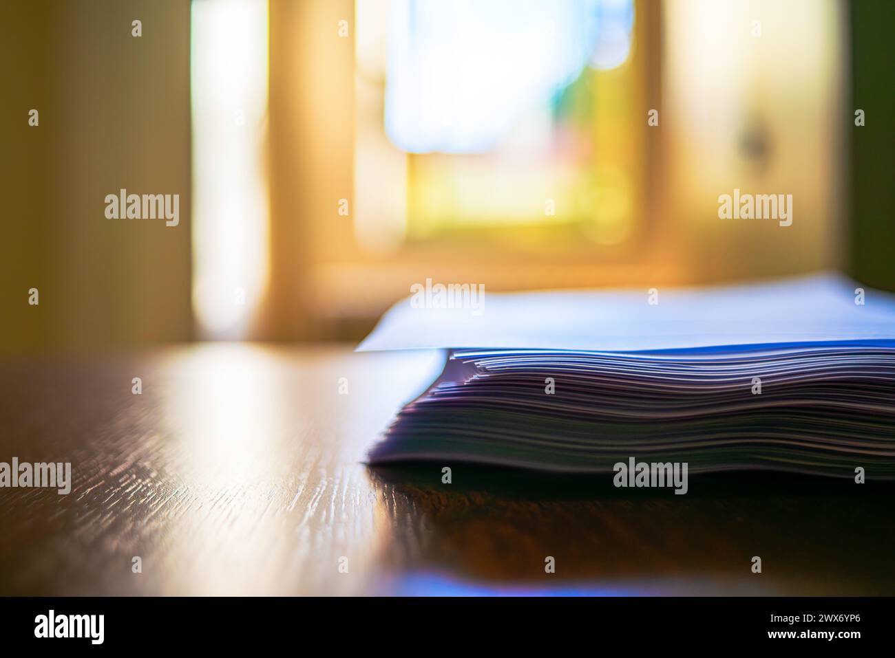 Papiers sur un bureau avec une boîte à crayons soigneusement placée, capturant le chaos organisé du travail ou de l'étude. Banque D'Images