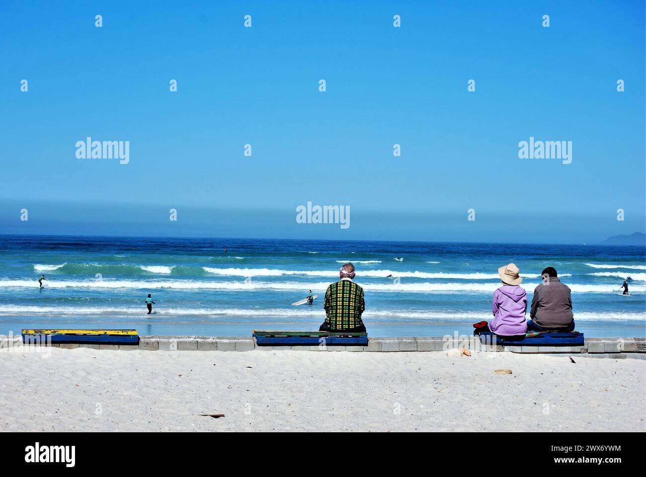 Les gens face à l'océan plage Muizenberg Banque D'Images