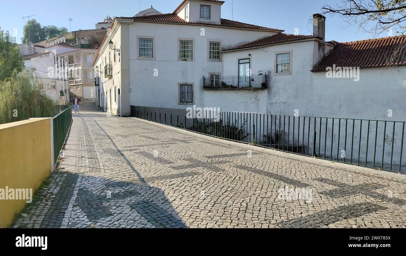 Chaussée pavée ornementée du pont traversant la rivière Almonda, rue Alexandre Herculano, Torres Novas, Portugal Banque D'Images
