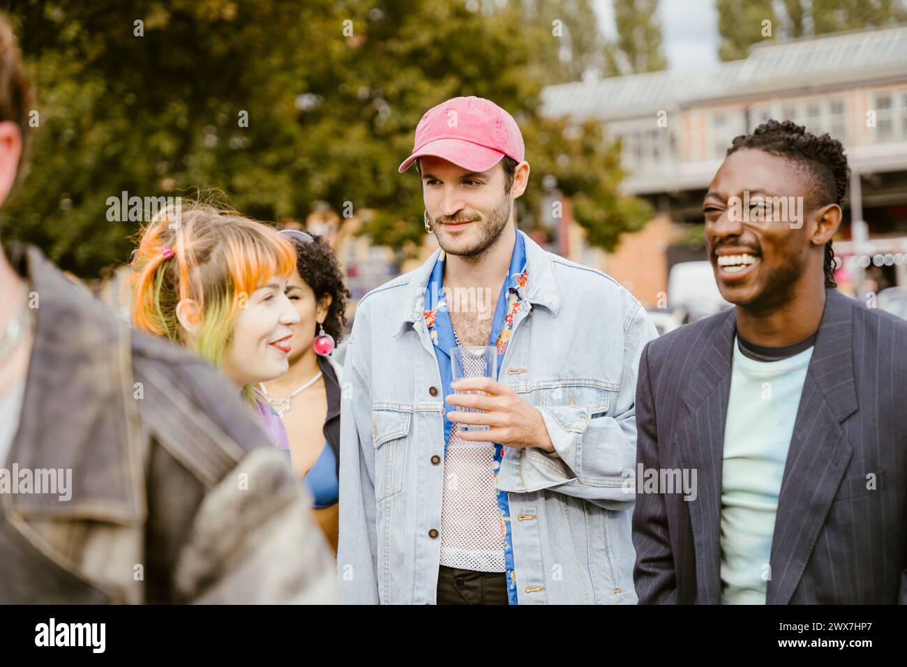 Heureux amis non binaires jouissant ensemble dans la ville Banque D'Images