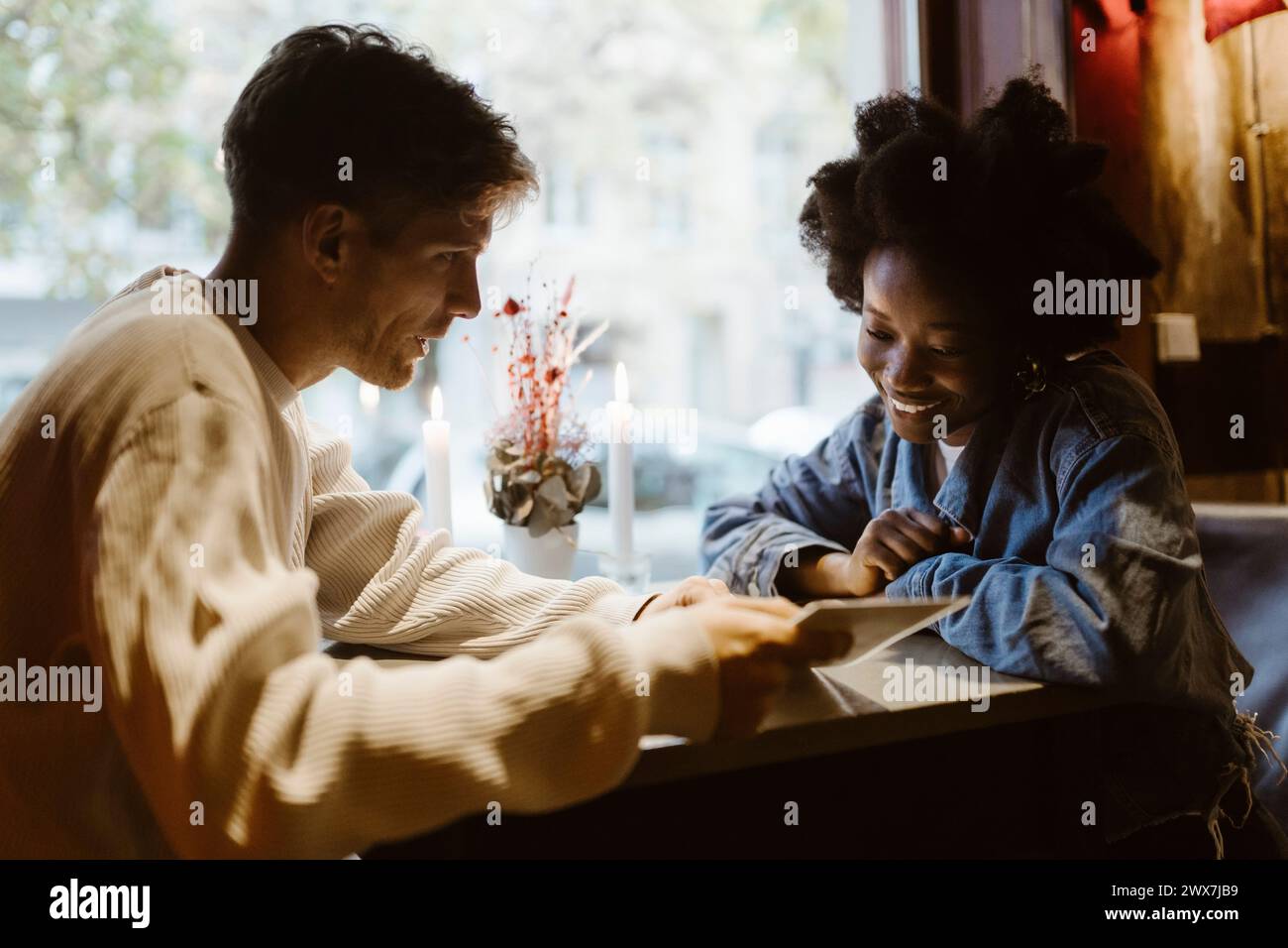 Petit ami suggérant un plat à petite amie regardant la carte de menu dans le restaurant Banque D'Images