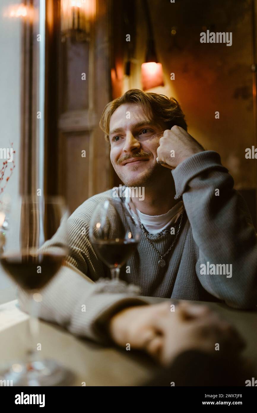 Homme gay souriant à la date avec petit ami au restaurant Banque D'Images